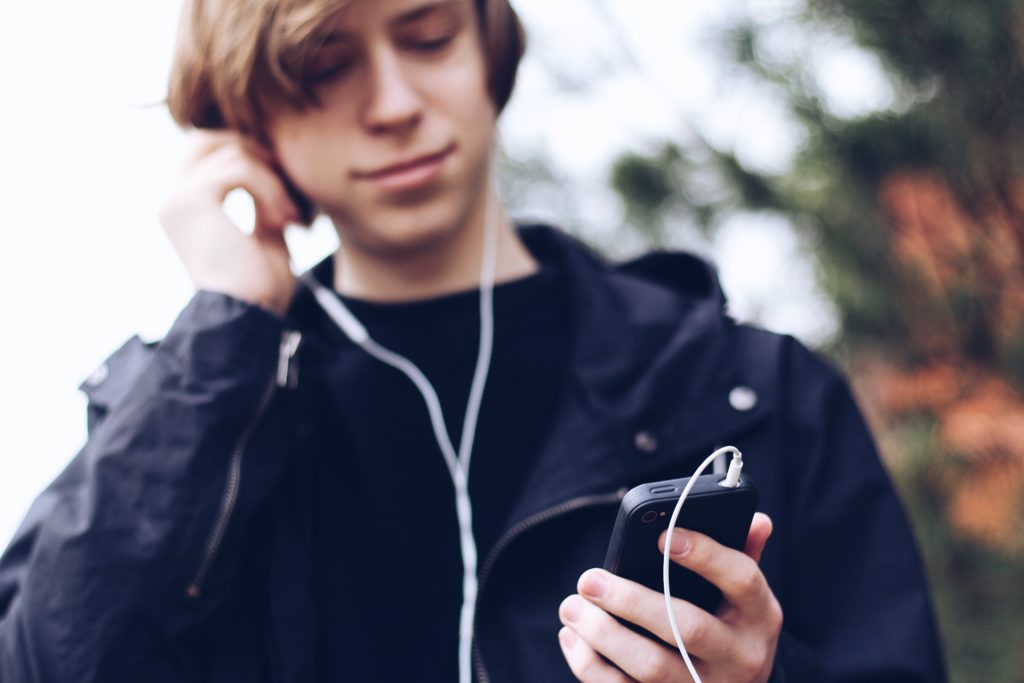tips for internet safety teen boy on phone with headphones